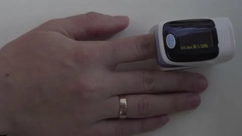 Close up of digital pulse oximeter on woman's finger, medical monitoring device  Stock Footage 164110766