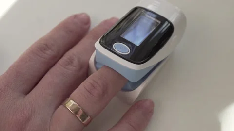 Close up of digital pulse oximeter on woman's finger, medical monitoring device  Stock Footage 164110776