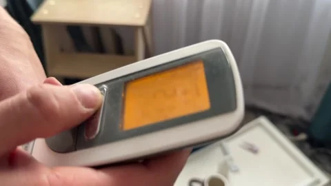 Close up of digital remote control with illuminated screen showing temperature Stock Footage 337104955