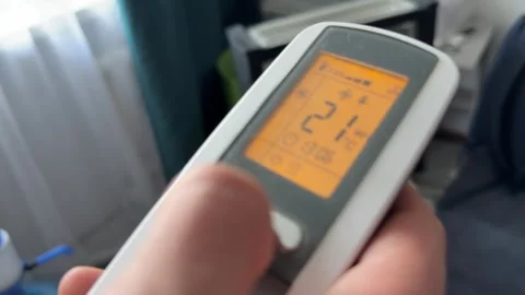 Close up of digital remote control with illuminated screen showing temperature Stock Footage 337104969