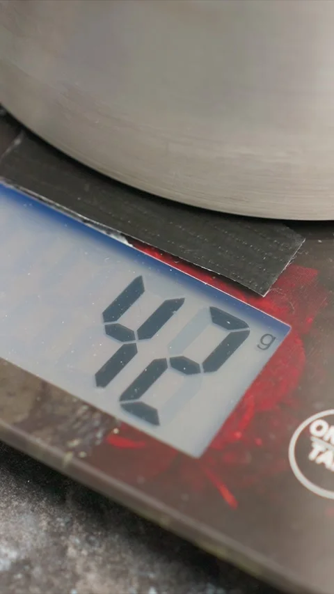 Close up of digital scale displaying weight measurement in grams with changing Stock Footage 345724815