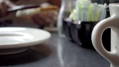 Close-up diner table hand spreading jam jelly on toast taking bite 4K Stock Footage 80968587