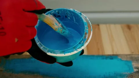 Close up of dipping brush into blue paint outside. Home renovation. Blue paint Stock Footage 200774270