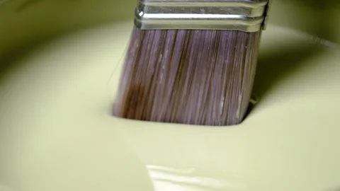 Close up of dipping a paint brush into a bucket of paint Stock Footage 138956325