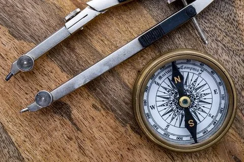 Close up of directional compass drawing compass on wooden surface Foto stock