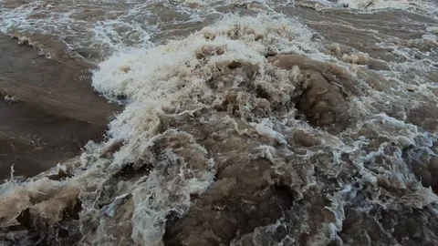 Close up dirty brown chaotic river water after autumn rainfall Stock Footage 120785893