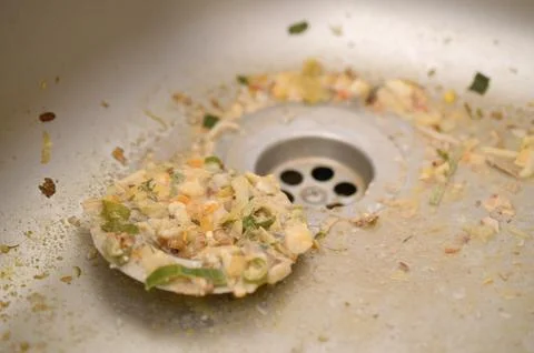 Close up on dirty clogging kitchen sink drain with food particles Stock Photos