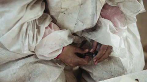 Close Up of Dirty Hands Holding Chess Piece in Worn Protective Suit Stock Footage 317985221