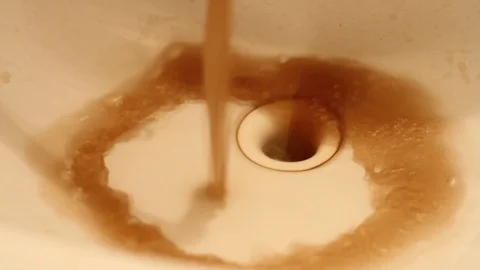 Close up dirty rusty brown polluted water flowing from tap in bathroom sink.  Stock Footage 125053137