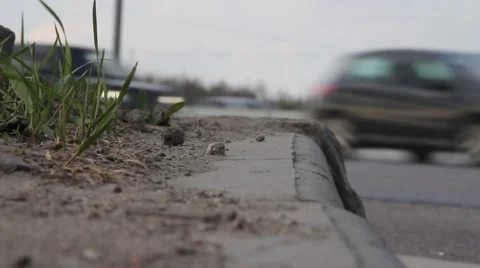 Close up of dirty sidewalk and passing cars in background Stock Footage 44858864