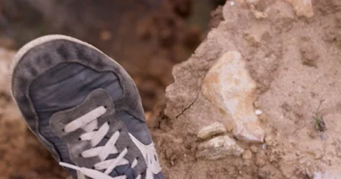 Close up of dirty sneaker shoe pushing away dried up soil to fall down off cliff 스톡 동영상 149291780