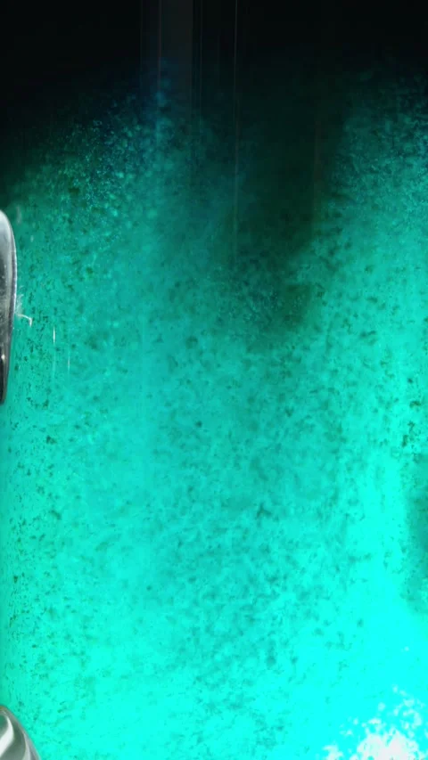Close-up of a dirty turquoise-green liquid with dense suspended dark flakes Stock Footage 340637958