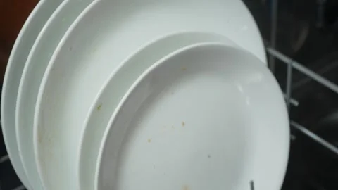 Close-up of dirty, white plates being placed inside of a dishwasher Vídeos de archivo 313907997
