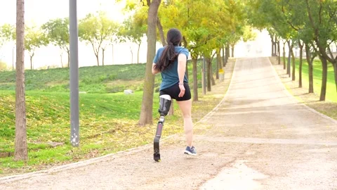 Close-up of a disabled man with prosthetic leg running outdoors Stock Footage 260558751