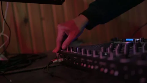 Close up of a disc jockey's hands adjusting knobs and faders on a sound mixer Stock-Footage 327684446