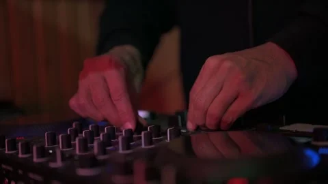 Close up of a disc jockey's hands manipulating faders and knobs on a sound Stock-Footage 327684444