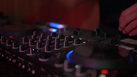 Close up of a disc jockey's hands skillfully manipulating the knobs and faders Stock-Footage 327684495
