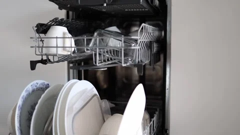 A close-up of a dishwasher loaded with clean dishes, cups, and plates. The neatl Stock Footage 301106738