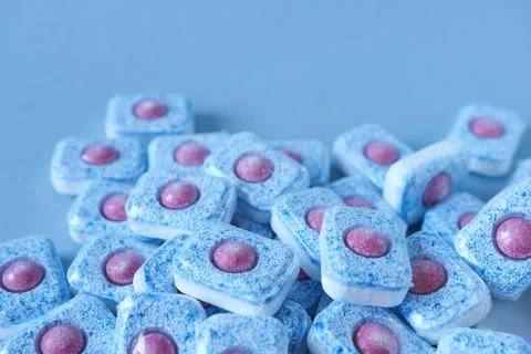 Close-up of dishwasher tablets on blue background. Stock Photos