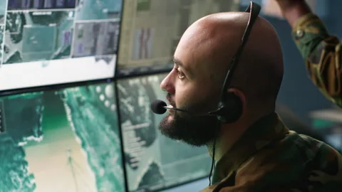 Close up on dispatcher working in war room operating surveillance tech Video stock 282057032