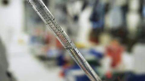Close up dispensing clear liquid in scientific lab looking for a cure to a virus Stock Footage 127532749