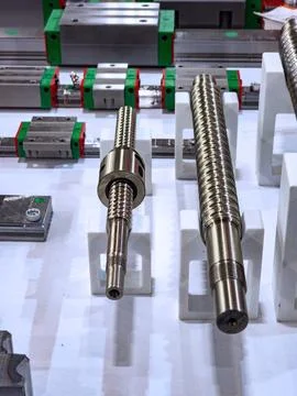 A close-up display of high-precision ball screws with nuts and linear guide r Stock Photos
