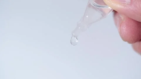 Close-up: Disposable eye drop vial administering solution into an open eye. Stock Footage 320826096