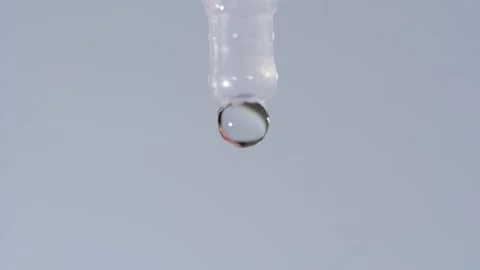 Close-up: Disposable eye drop vial administering solution into an open eye. Stock Footage 320826101