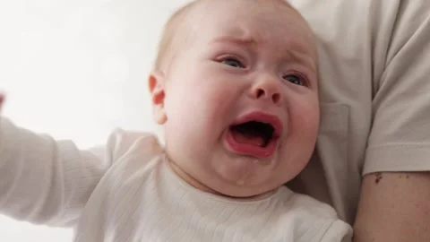 Close-up of a distressed baby's face with tears and open mouth Stock Footage 340580898