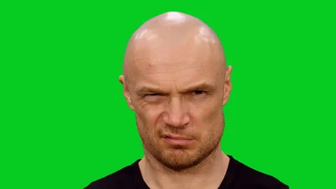 Close-up of distrustful angry bald man looking at camera on green screen 스톡 동영상 130796741