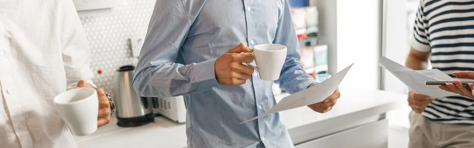 Close up of diverse coworkers drink coffee during break and talking about work Stock Photos