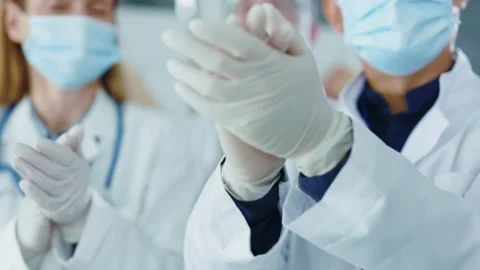 Close-up of diverse multi-cutlural doctors in medical masks and gloves clapping 動画素材 142846153