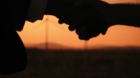 Close up of diverse partners shaking hands among windmills. Businessmen and Stock Footage 170426061