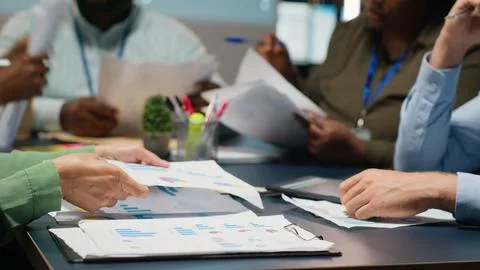 Close up of diverse specialists evaluating data numbers on archived files Stock Photos