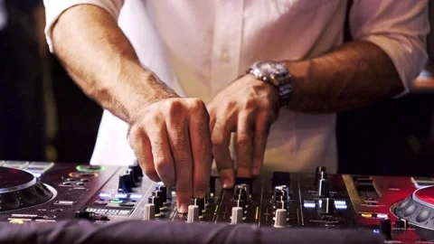 Close-up of DJ adjusting audio mixer controls at nightclub. Video stock 307916293