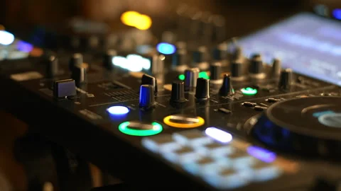 Close up of dj controller knobs glowing in dark nightclub Stock Footage 337791064