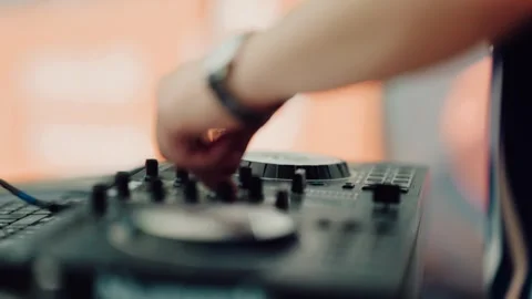 Close up of DJ hands adjusting knobs on mixing console at a club party, blurred Stock-Footage 342760979
