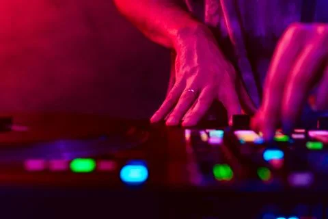 Close up of DJ hands on dj console mixer during concert in the club Stock Photos