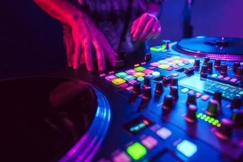 Close up of DJ hands on dj console mixer during concert in the club Stock Photos
