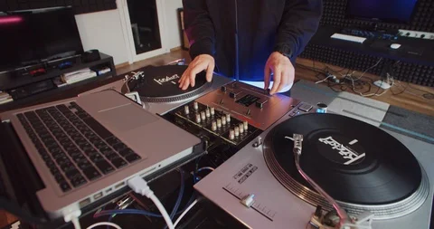 Close-up DJ hands twisting vinyl touching knobs on sound mixer indoors. DJ 스톡 동영상 114344920