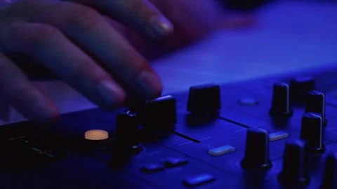 Close-up: DJ man hands playing set in night club, controling sound console Stock Footage 329085602