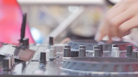 Close up DJ works on the DJ console, adds volume levels. Stock Footage 94219665