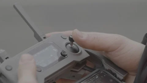Close-up of a DJI Mavic drone remote controller, man piloting the drone and Stock Footage 165391471