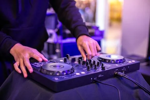 Close-up of a DJ's hands operating a modern digital DJ controller with illu.. Stock Photos
