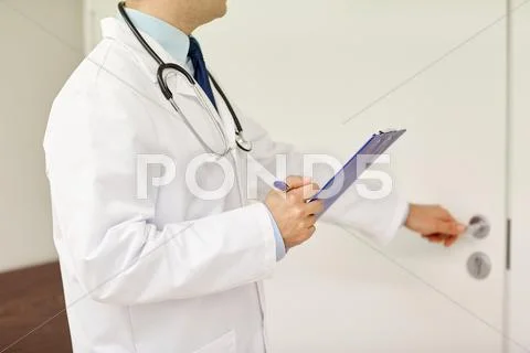 Close Up Of Doctor With Clipboard At Hospital Door