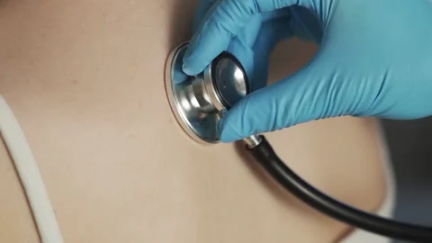 Close-up of doctor hand using stethoscope with a female patient, checking the Stock Footage 146504926