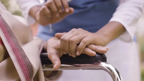 Close up of doctor hands consoling eldery by holding hand on wheelchair - Stock Footage 182338653