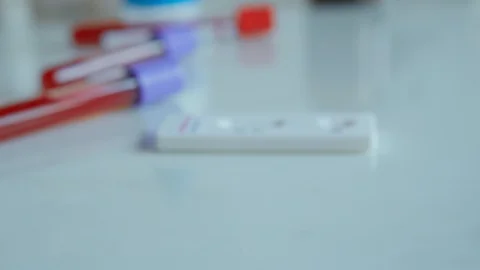 Close-up doctor hands put on table test tube with blood sample for COVID-19 Stock Footage 128873186