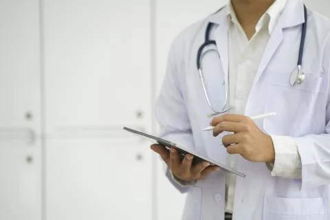 Close up of doctor hands using digital tablet at clinic. Stock Photos