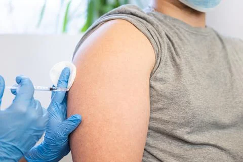 Close up of a Doctor making a vaccination in the shoulder of patient. Concept Foto stock